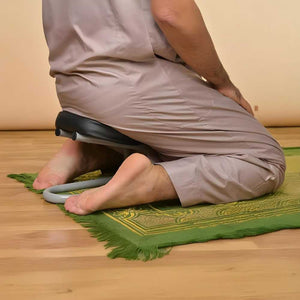 Person using a kneeling pad on a green prayer mat with a beige background