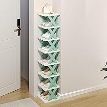 Shoe rack with multiple pairs of shoes against a white wall.