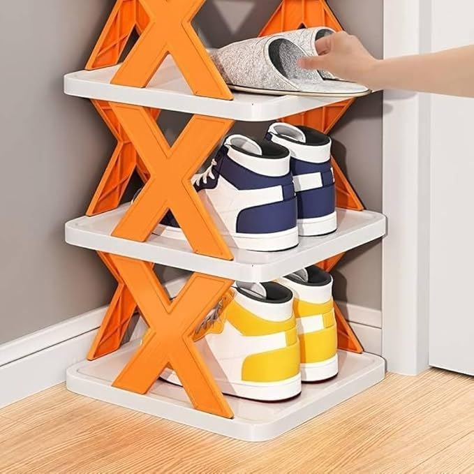 Shoe rack with orange and white design holding various shoes on a wooden floor.